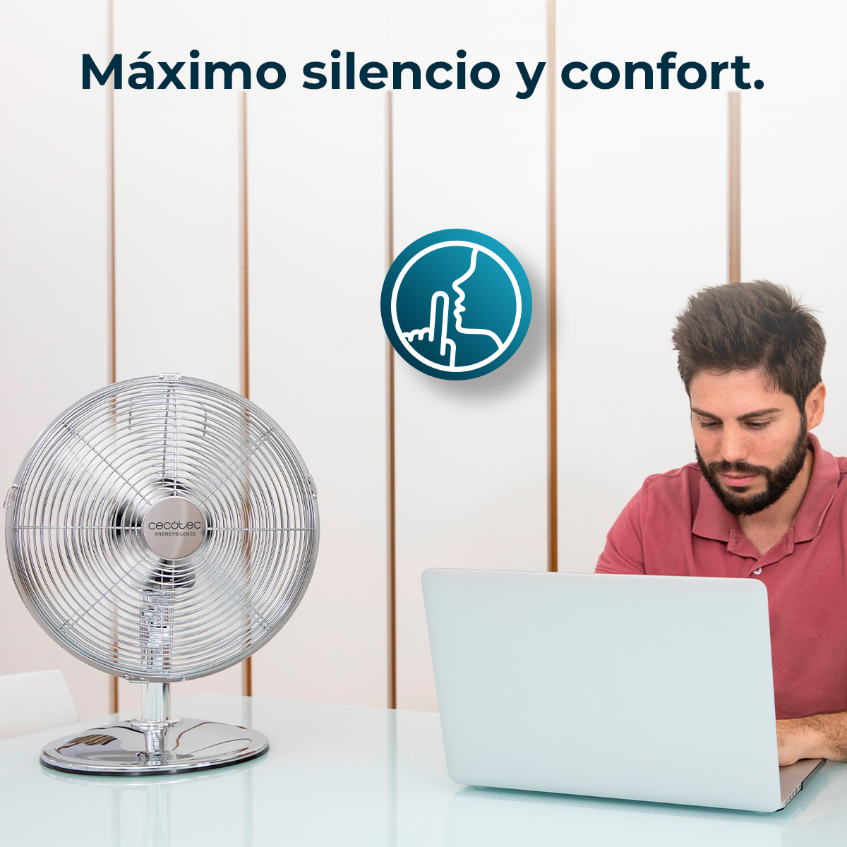 Un uomo lavora al computer portatile vicino a un ventilatore. È visibile un simbolo di silenzio.