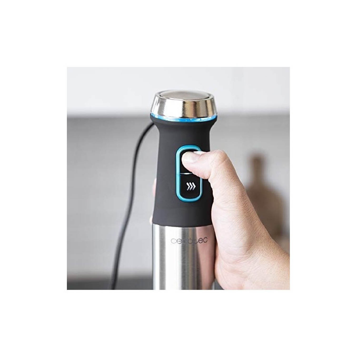 Eine Hand drückt einen schwarzen Stabmixer mit blauem Akzent und Metallbasis.