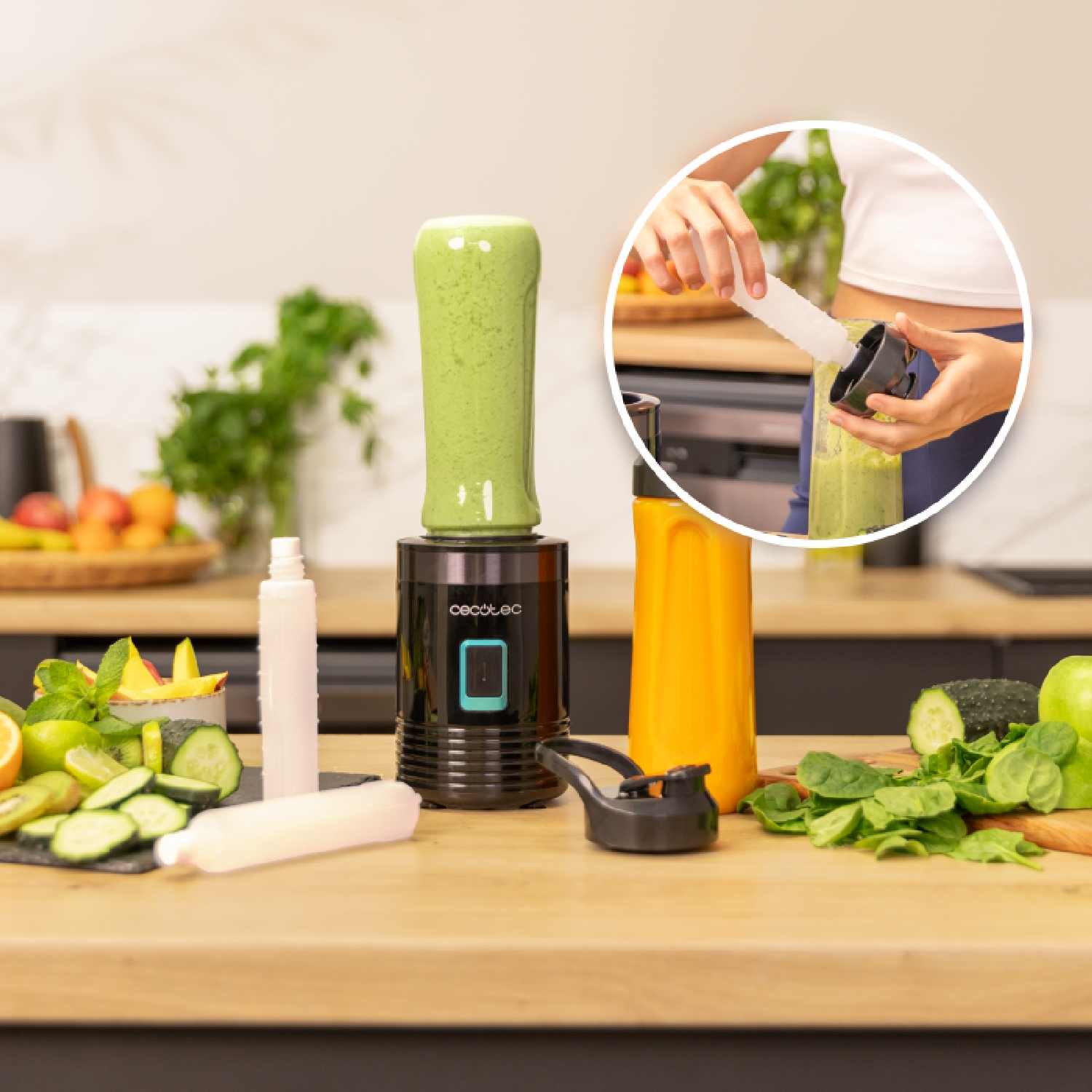 Grüner Smoothie im Mixbecher, mit Obst und Gemüse auf der Theke.