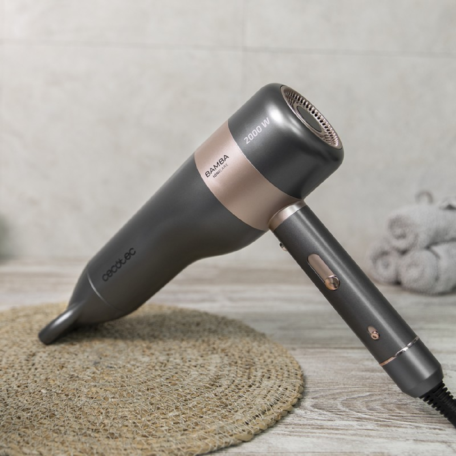 Un asciugacapelli grigio scuro con accenti oro rosa poggia su una superficie.