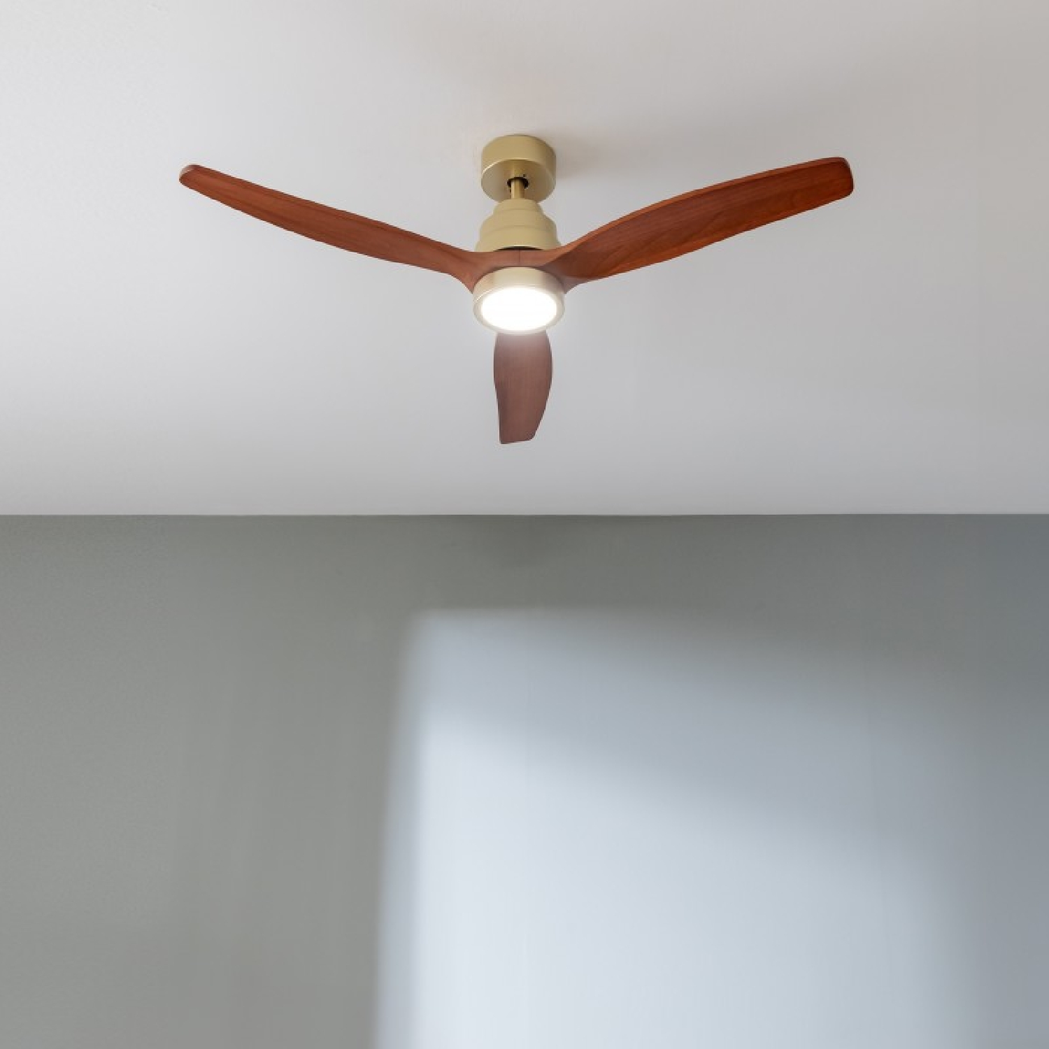 A modern ceiling fan with three wooden blades and built-in light.