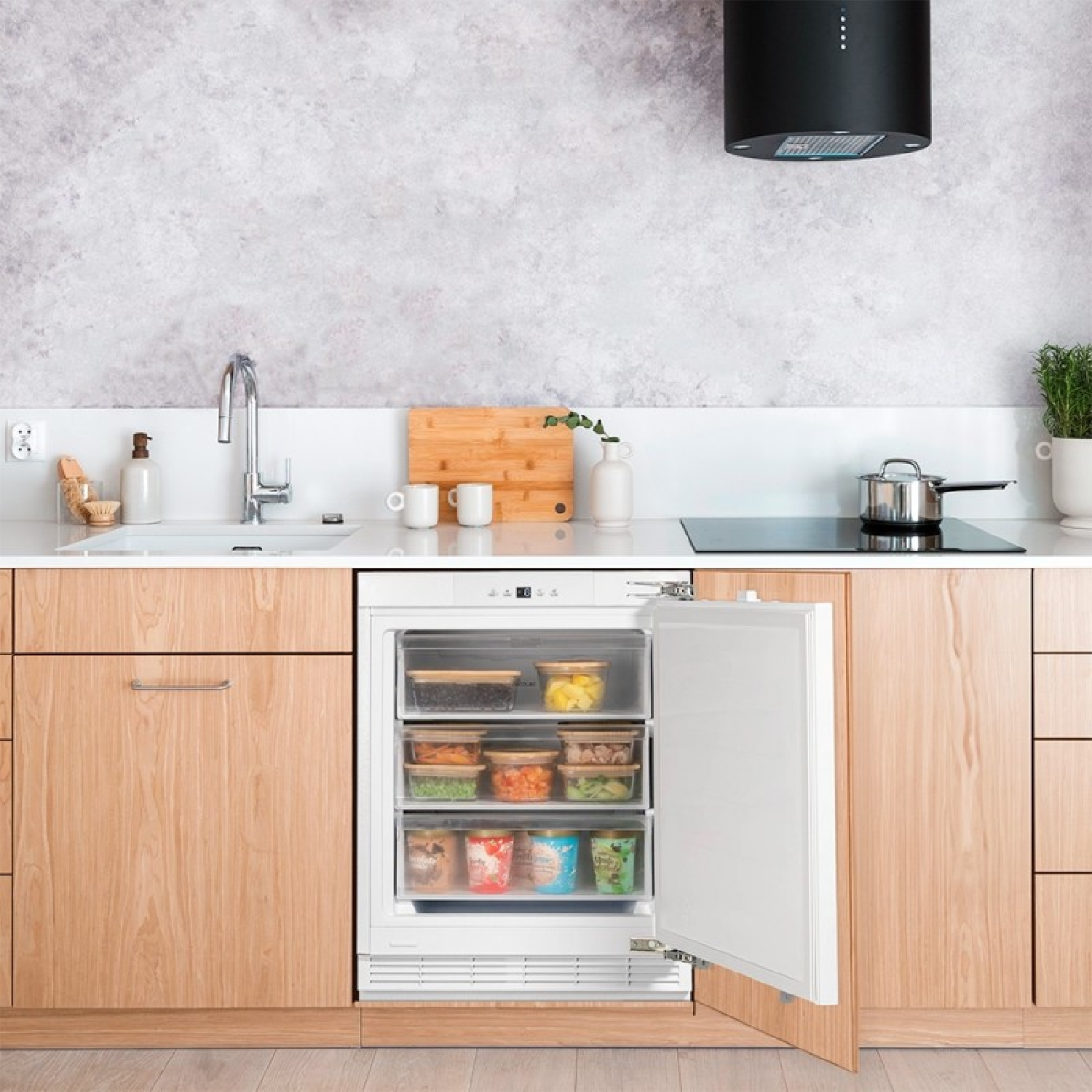 Refrigerador abierto en una cocina con gabinetes de madera y pared de concreto.
