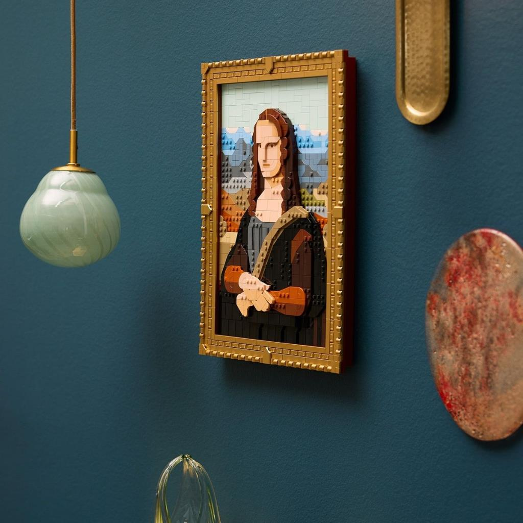 Teal duvarda çerçeveli Lego Mona Lisa, modern sarkıt lamba ile.