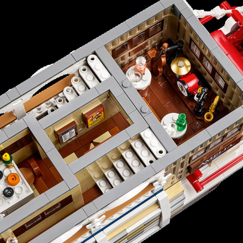 Oda, merdiven, davul seti ve enstrümanları olan Lego tekne iç modeli.