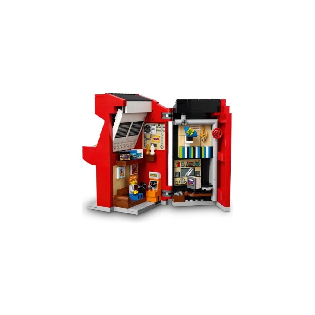 İçinde video oyunları oynayan bir adamın olduğu kırmızı Lego bina.