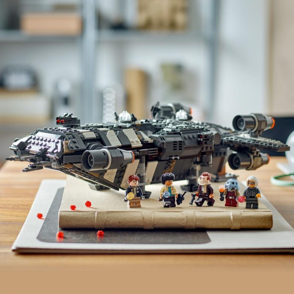 Bulanık arka plana karşı kahverengi zemin üzerinde beş figürlü Lego uzay gemisi.