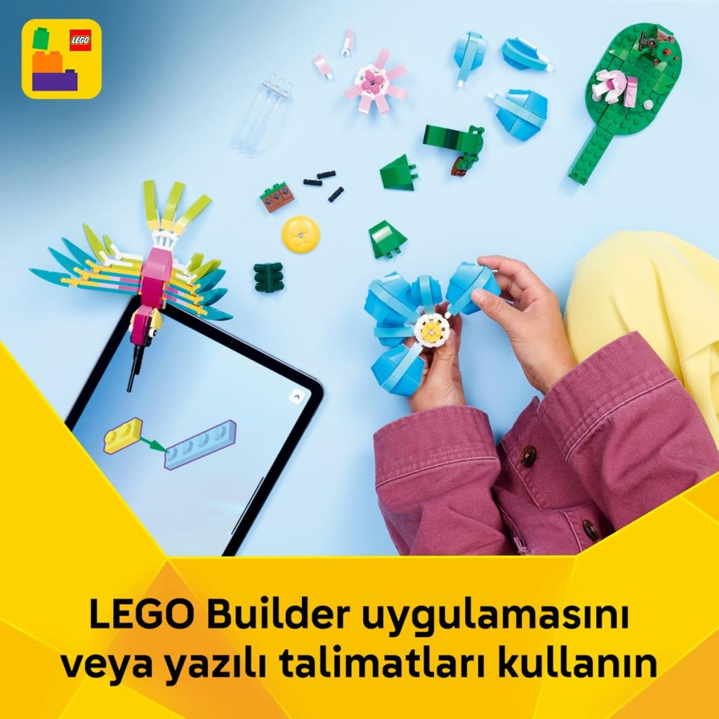 Dziecko buduje z klocków LEGO; instrukcje widoczne na tablecie.