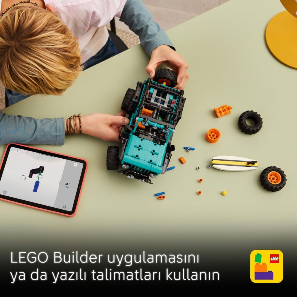 Dziecko buduje turkusowy samochód z klocków Lego i instrukcjami na tablecie.