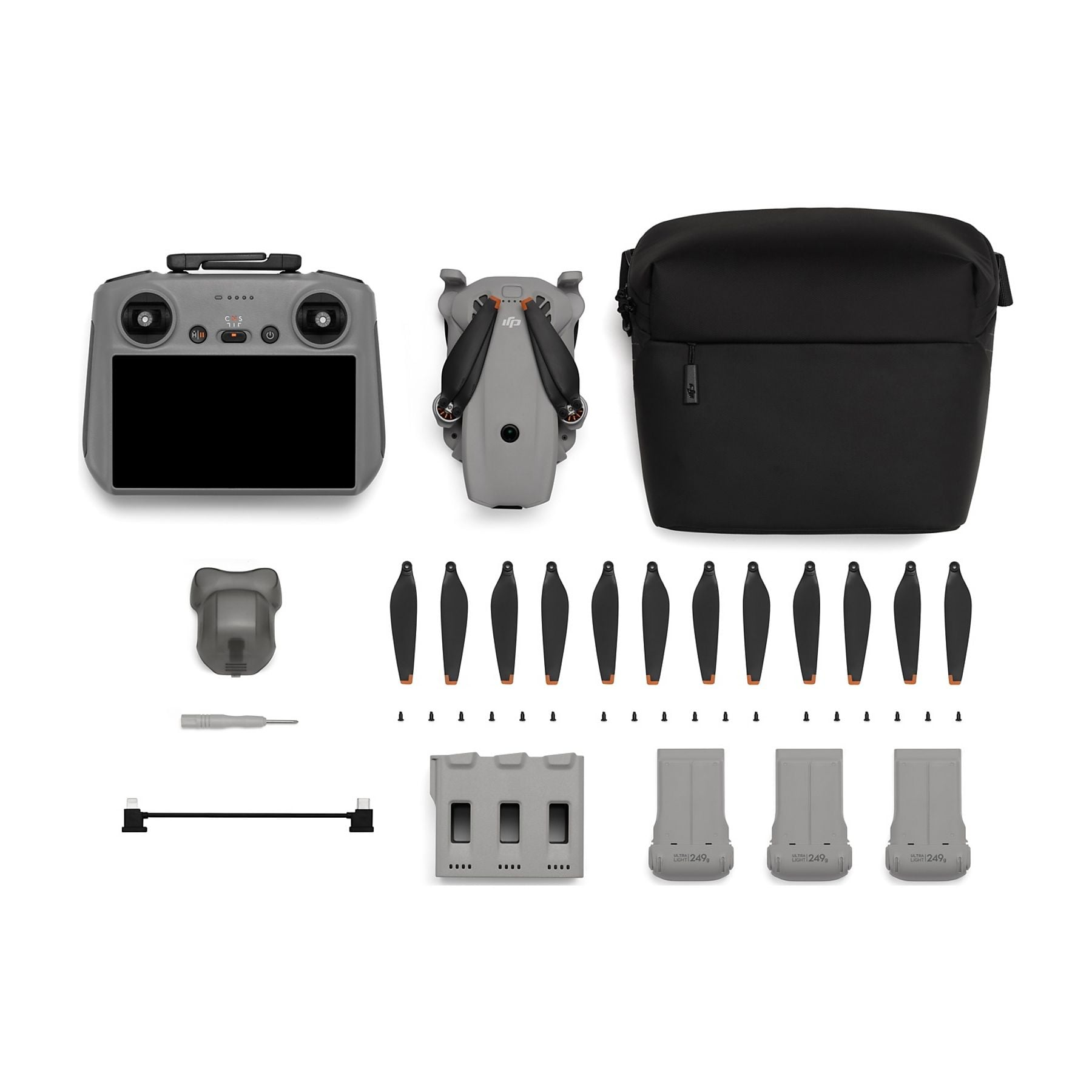 Controlador DJI gris, dron, bolsa, hélices de repuesto y baterías.