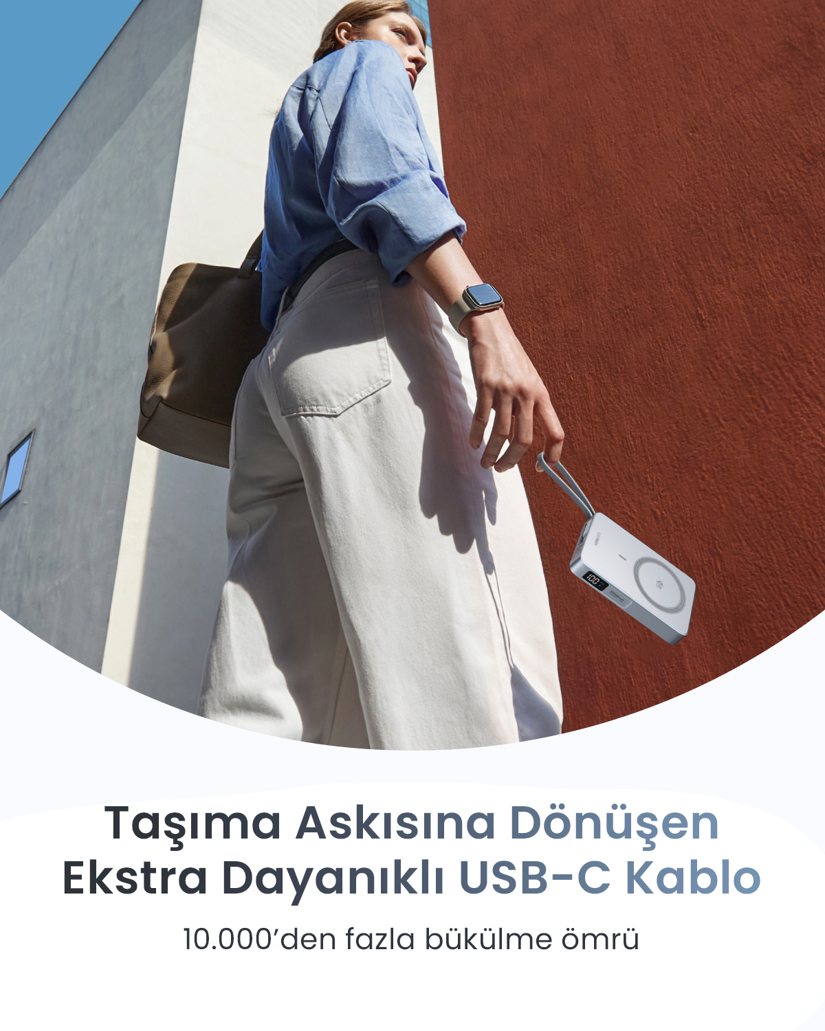 Kobieta z torbą trzyma srebrną ładowarkę z kablem USB-C.