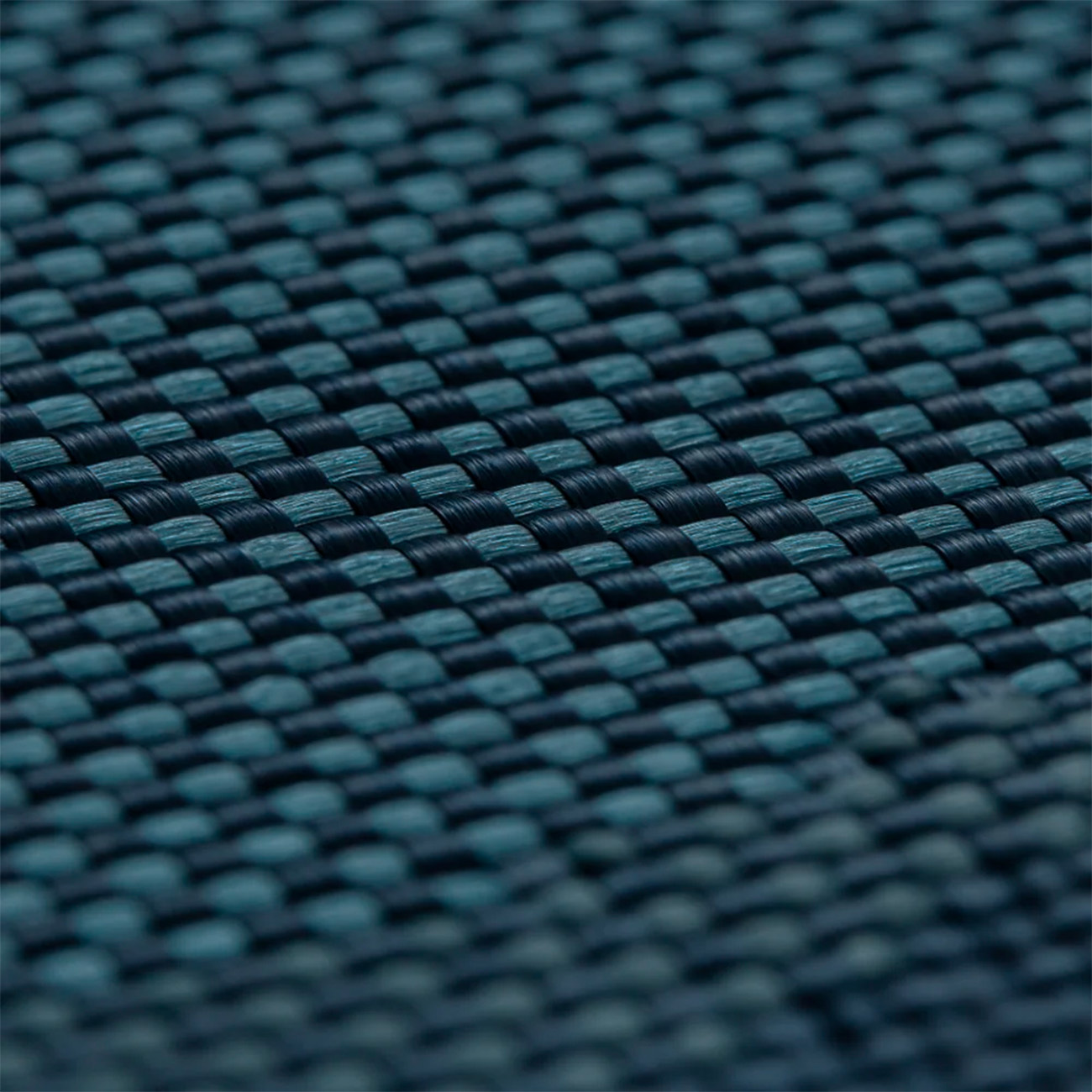 Primer plano de tela tejida azul oscuro y verde azulado con patrón de tablero de ajedrez.