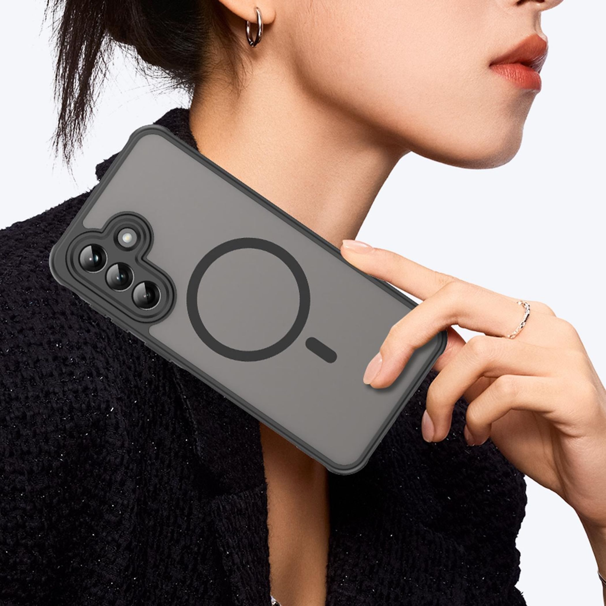 Eine Frau hält ein graues Handy mit MagSafe-Kreis und drei Kameras.