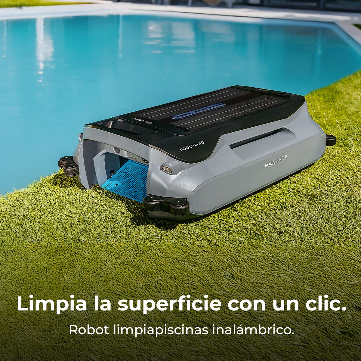 Un robot de piscina gris con panel solar sobre césped artificial verde junto a una piscina.