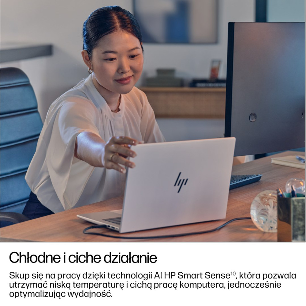 Azjatka pracuje na laptopie w biurze. Laptop HP jest otwarty.