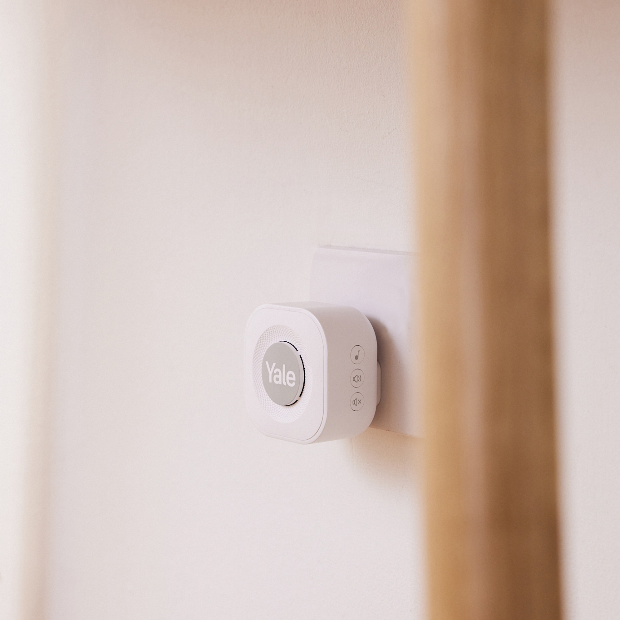 Un campanello Yale bianco è collegato a una presa a muro.