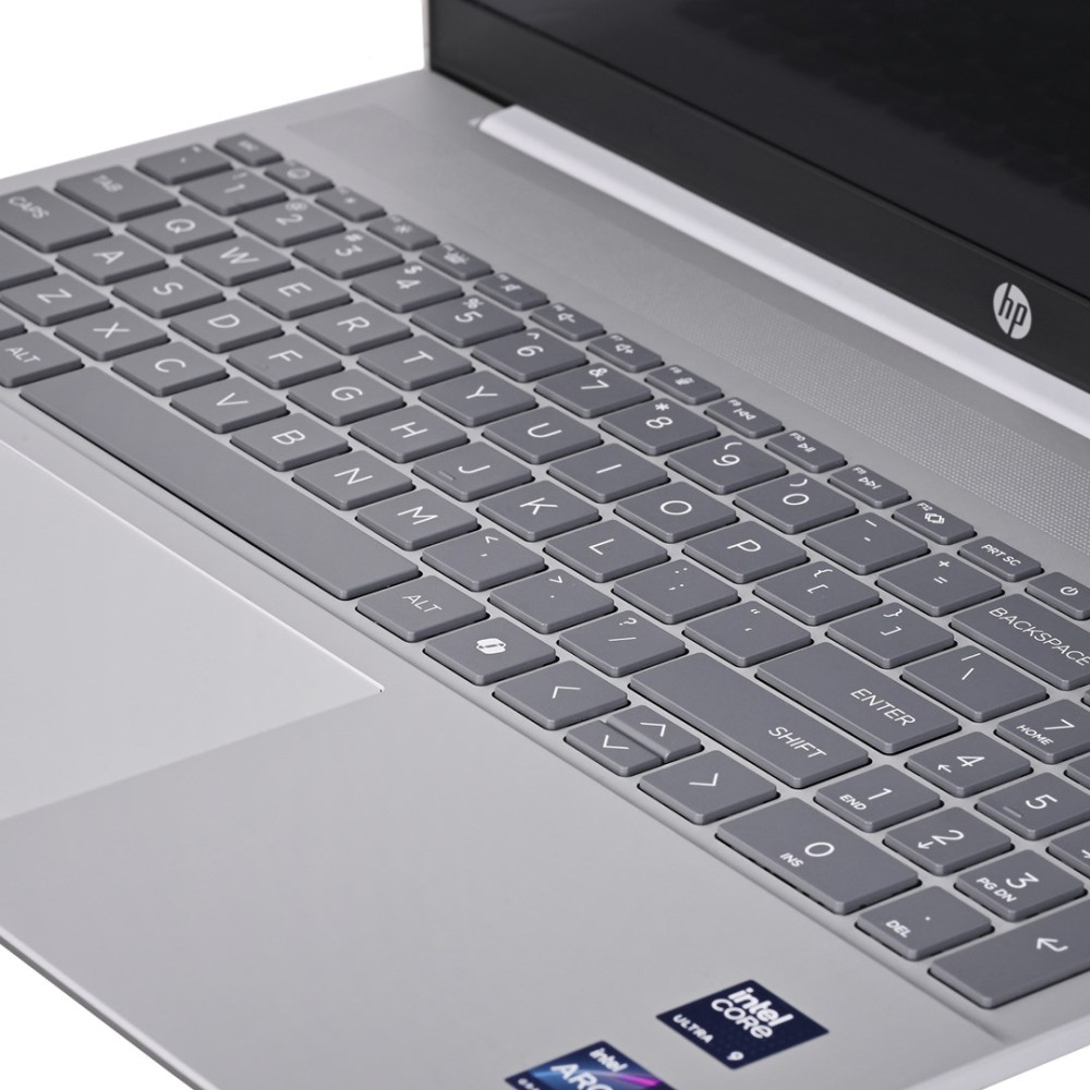 Zbliżenie szarej klawiatury laptopa na srebrnej obudowie.