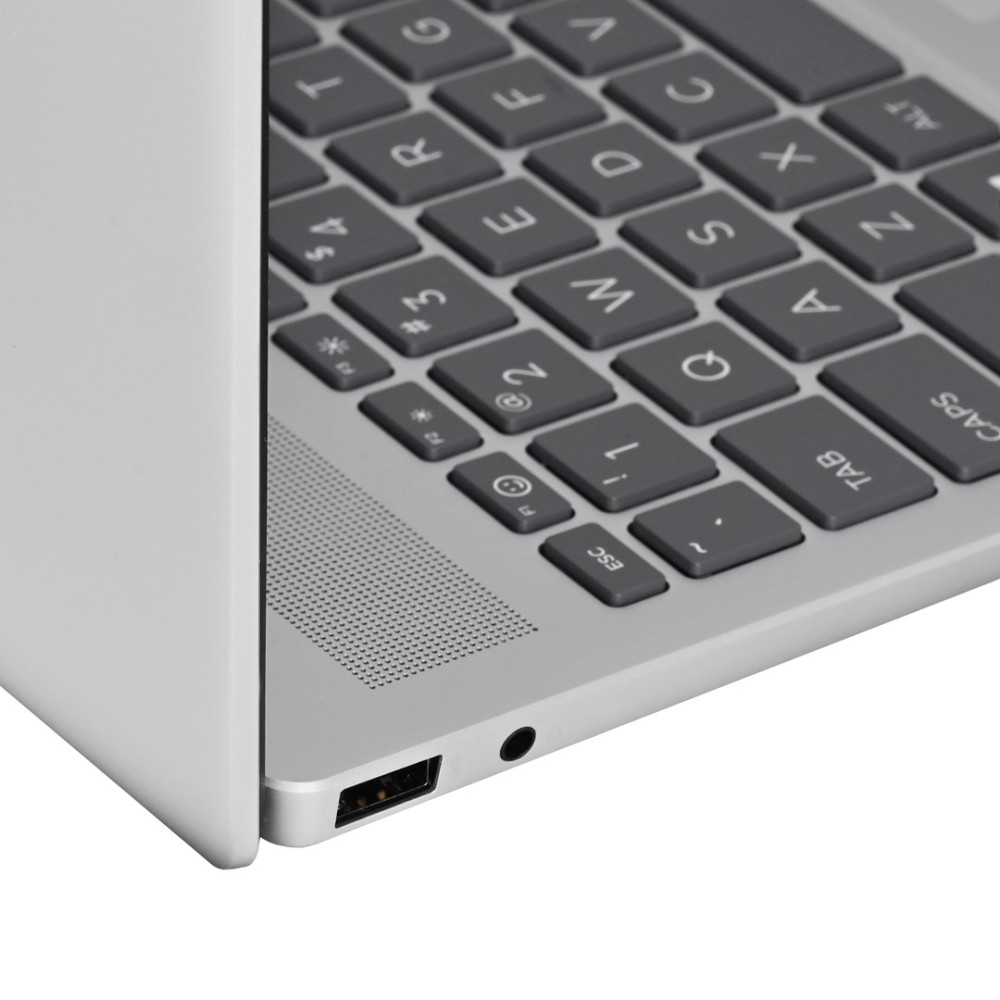 Zbliżenie klawiatury laptopa z szarymi klawiszami na srebrnej obudowie.