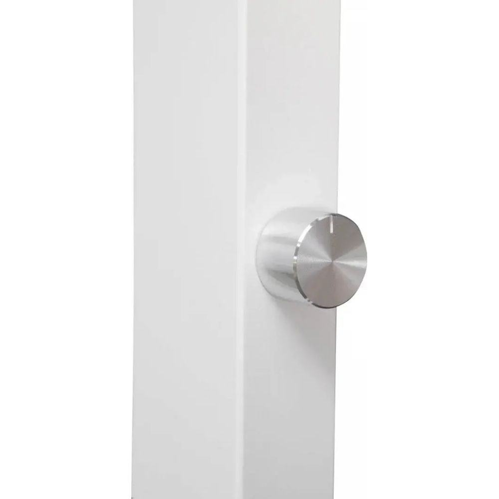 Una perilla giratoria plateada con marcas sobre una superficie blanca.