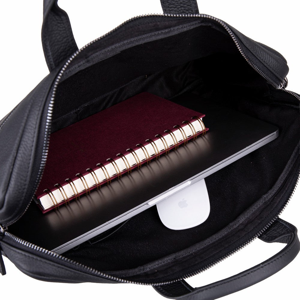 Açık fermuarlı siyah laptop çantası, içinde dizüstü bilgisayar, defter ve beyaz fare.