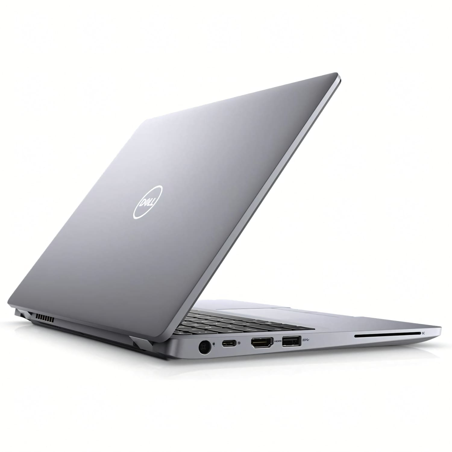 Un portátil Dell plateado está abierto, mostrando su teclado y puertos.