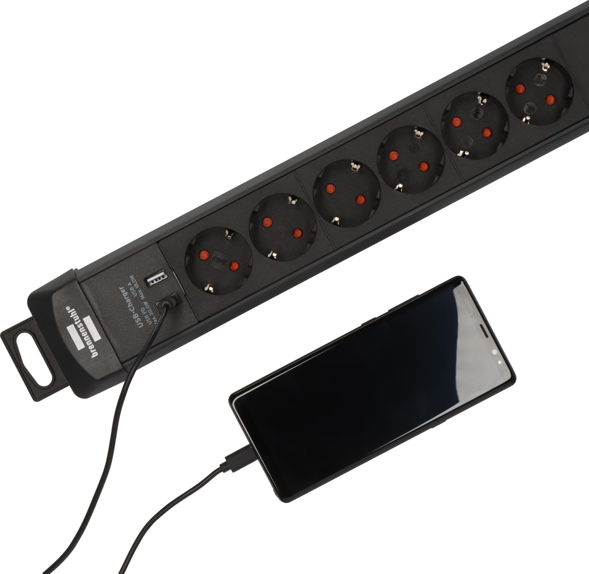 USB portlu siyah priz, bir akıllı telefonu şarj ediyor.