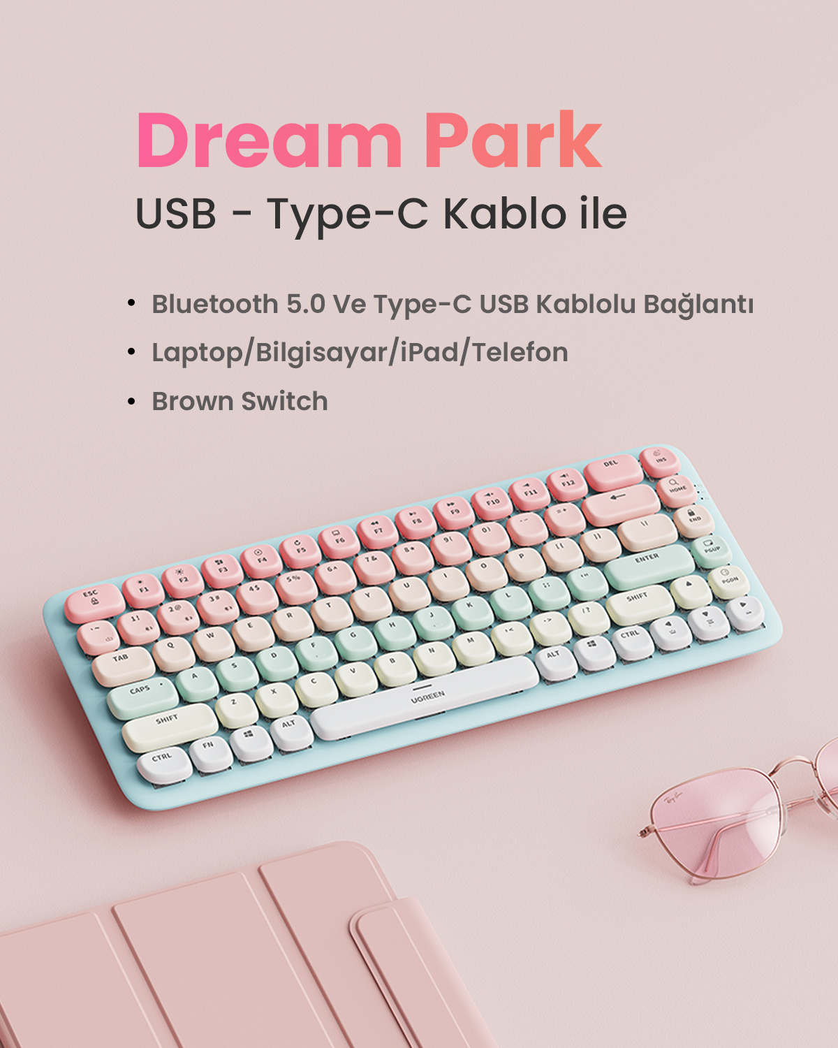 Pastel renkli klavye, Bluetooth/USB-C bağlantılı ve pembe güneş gözlüklü.