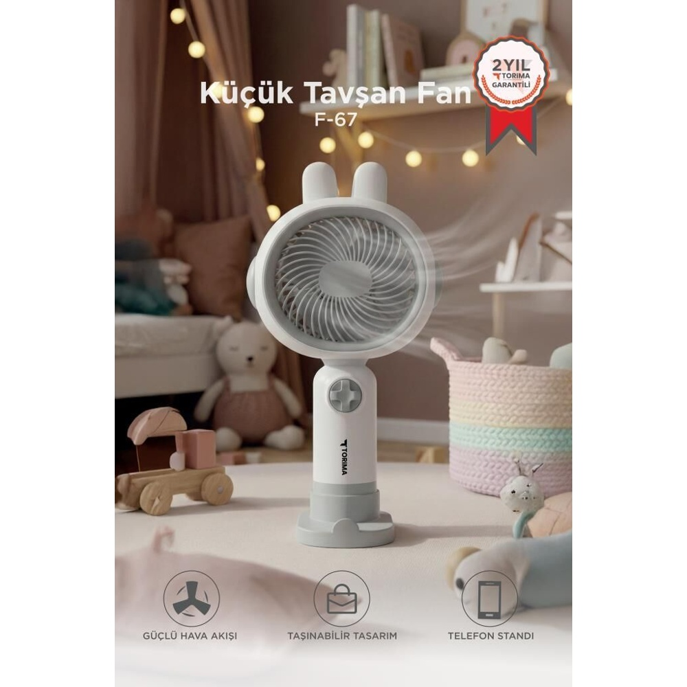 Halı üzerinde tavşan kulaklı küçük beyaz fan. Etrafta oyuncaklar var.