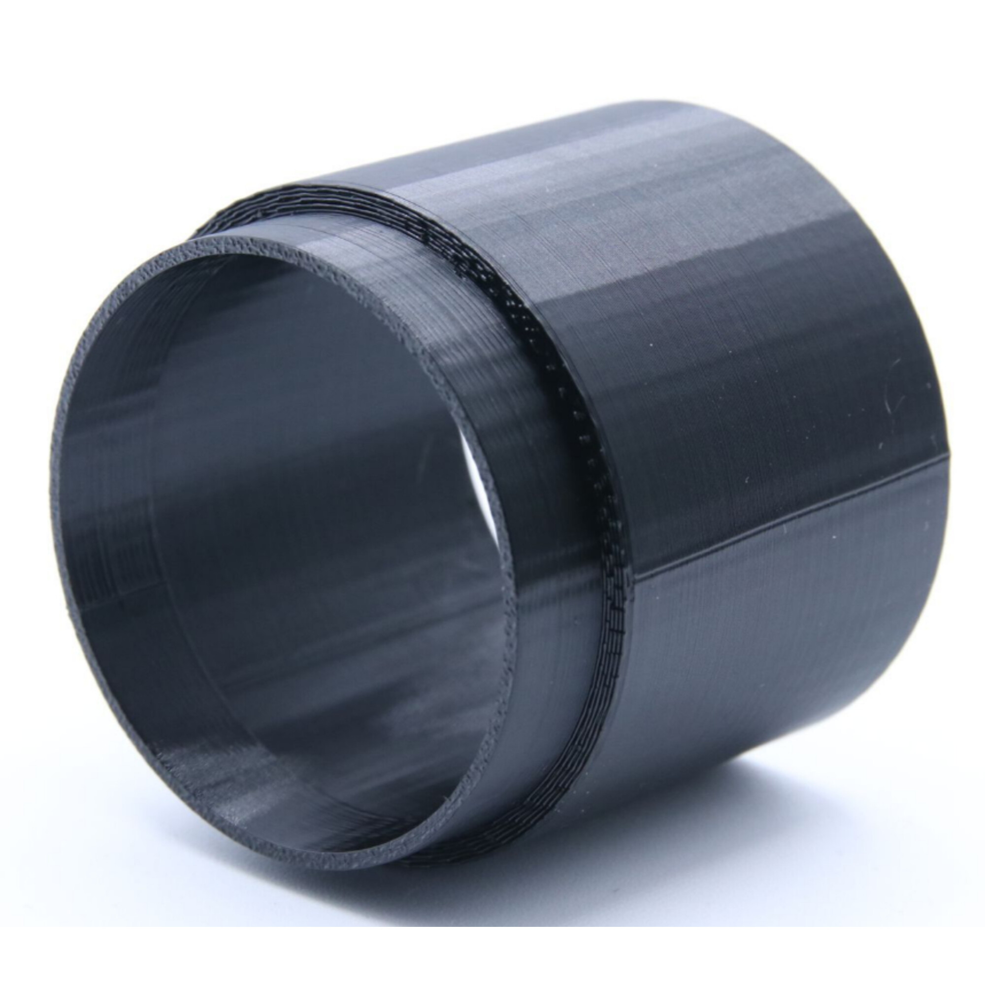 Ein schwarzer 3D-gedruckter Ring mit Schichten ist auf weißem Hintergrund abgebildet.