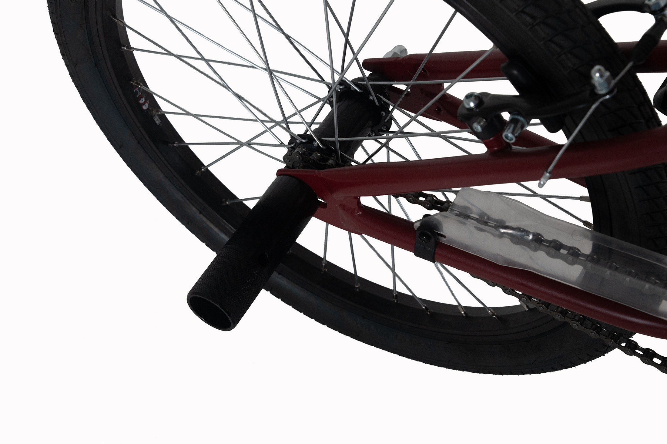 Nahaufnahme des Hinterrads eines roten BMX-Rads mit schwarzem Reifen und Speichen.