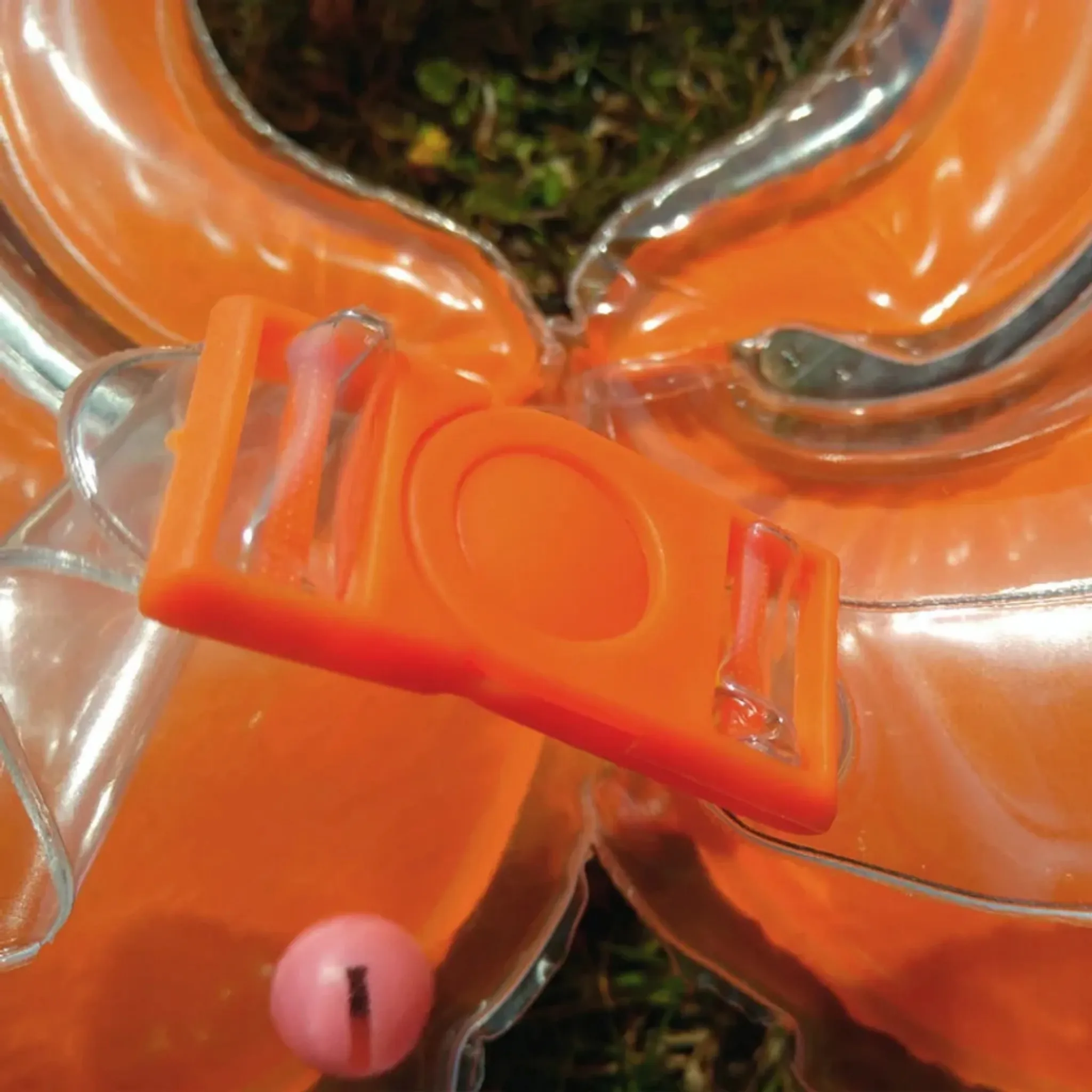Ein aufblasbarer Schwimmring in Orange mit einem rosa Ball und Schnallen.