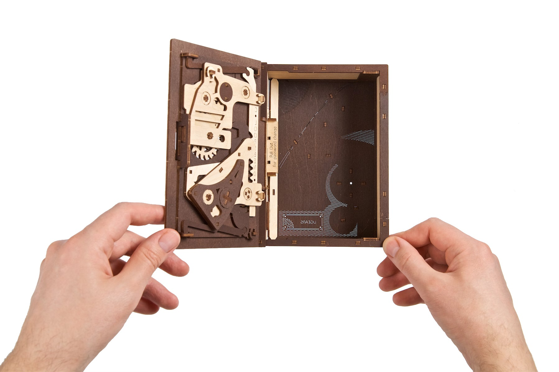 Zwei Hände halten eine hölzerne Aufbewahrungsbox mit offenem Deckel und sichtbaren Zahnrädern.