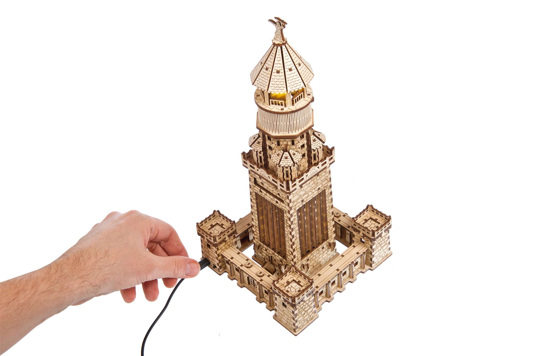 Holzmodell eines Leuchtturms, der an ein Kabel angeschlossen wird.