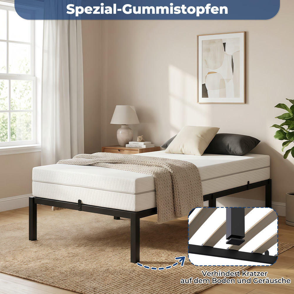Eine weiße Matratze auf einem schwarzen Metallbettgestell mit beiger Decke und Kissen.