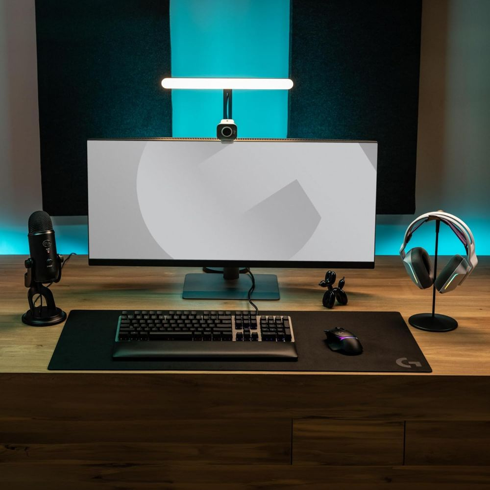 Ein Schreibtisch-Setup mit Monitor, Tastatur, Maus, Mikrofon, Kopfhörern und einem Ringlicht.