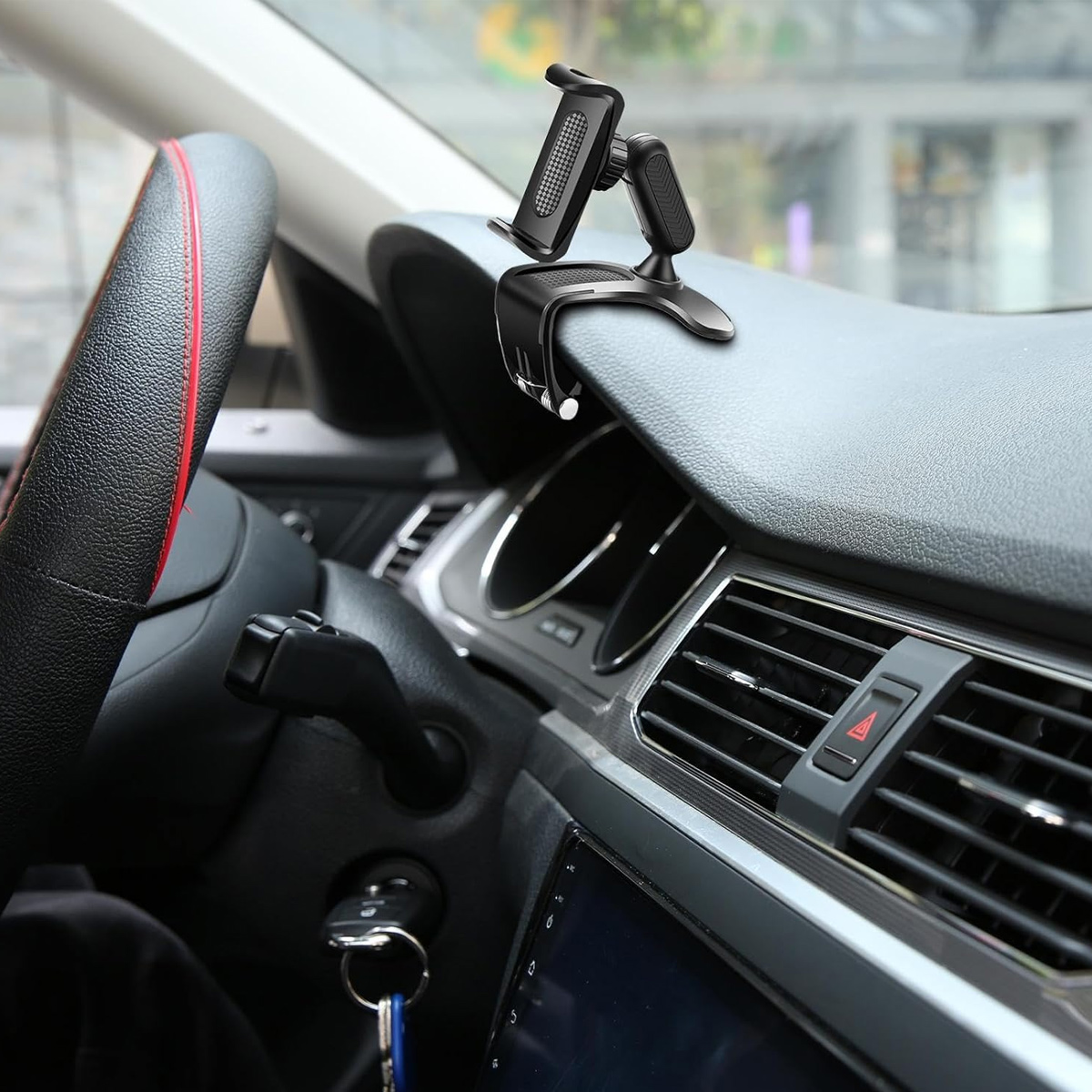 Armaturenbrett im Auto mit schwarzer Handyhalterung am Lüftungsschlitz.
