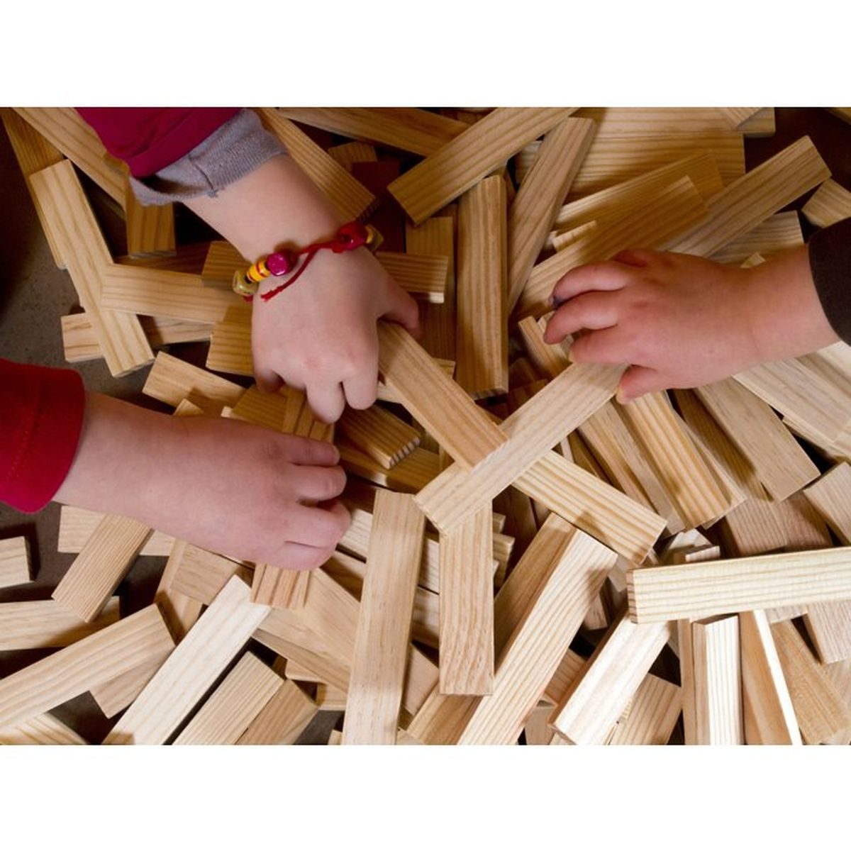 Mani di bambini che giocano con blocchi di legno. Primo piano.