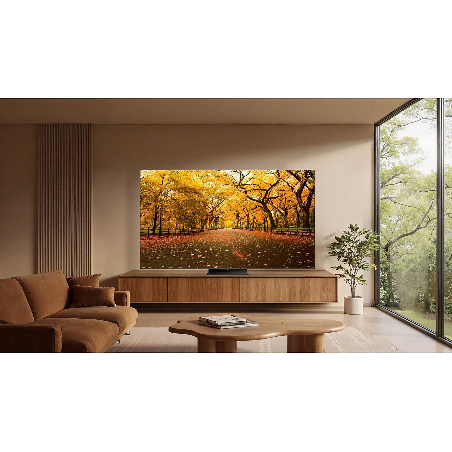 Una sala de estar con un televisor que muestra un camino de otoño.