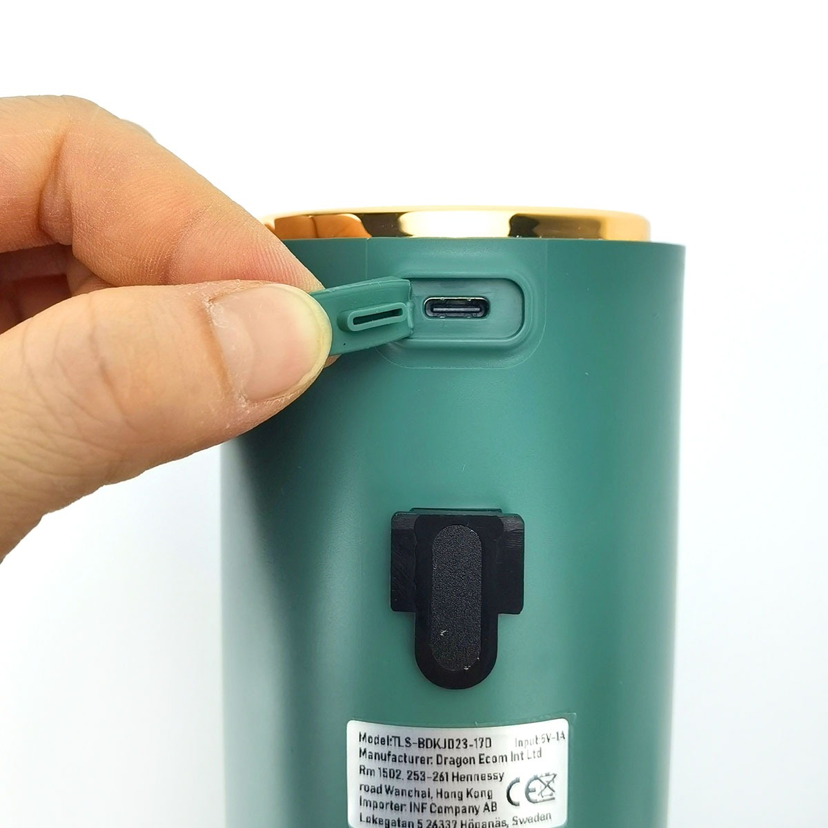 Ein Finger öffnet eine grüne Klappe für einen USB-C-Anschluss an einem grünen Gerät.