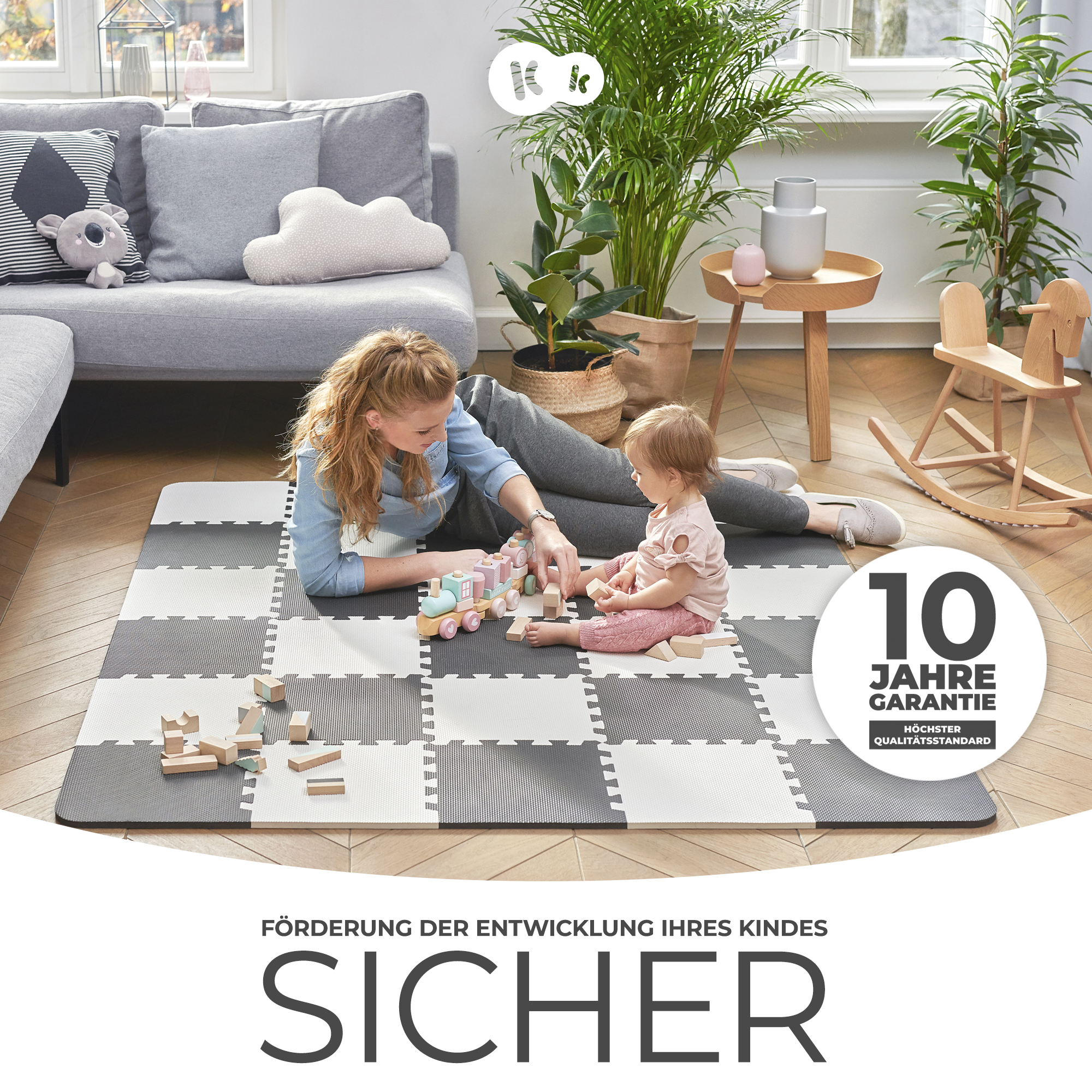 Frau spielt mit Baby auf Spielmatte mit Holzspielzeug. 10 Jahre Garantie.