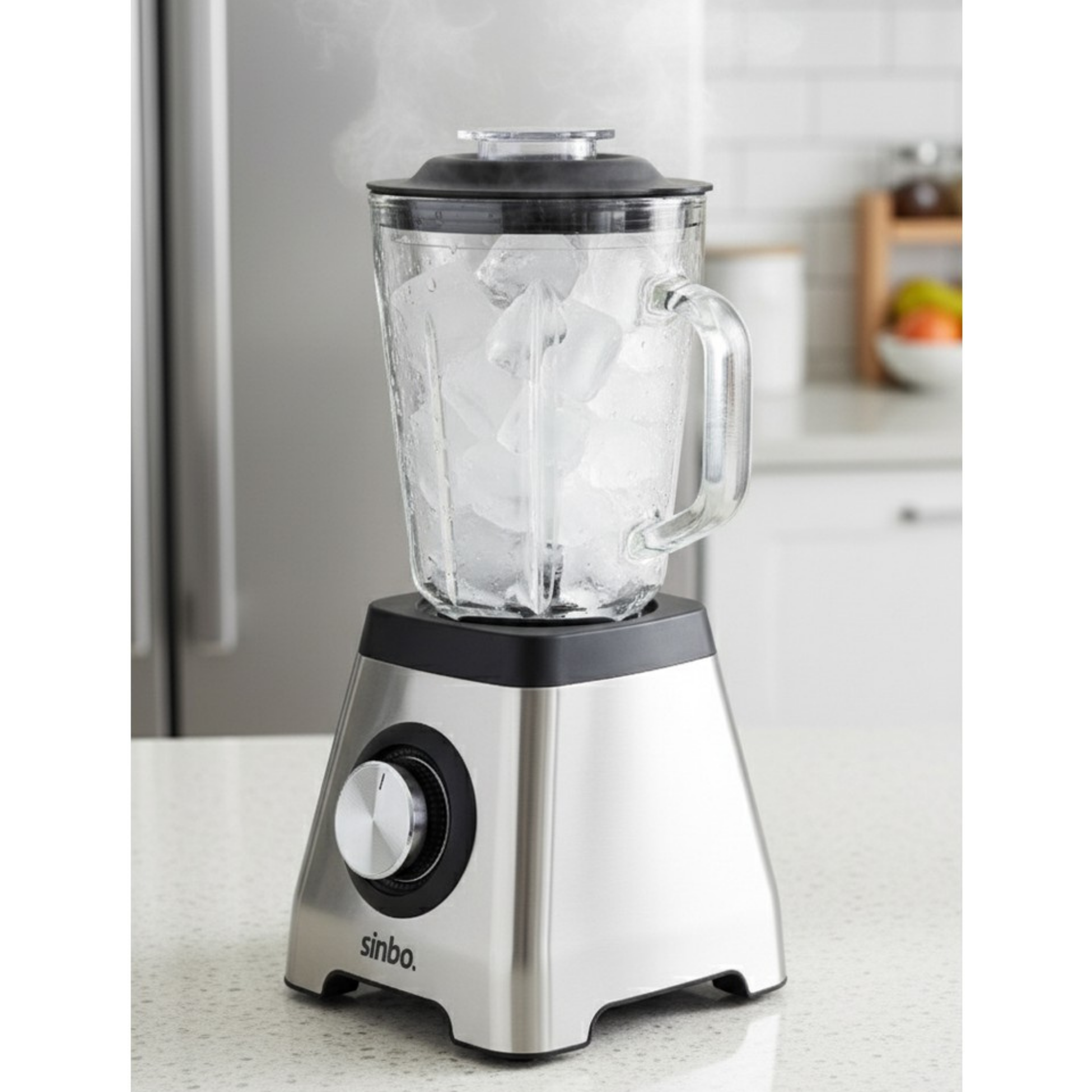 Gümüş renkli blender, cam haznesinde buz küpleri ve kapaktan yükselen buhar.