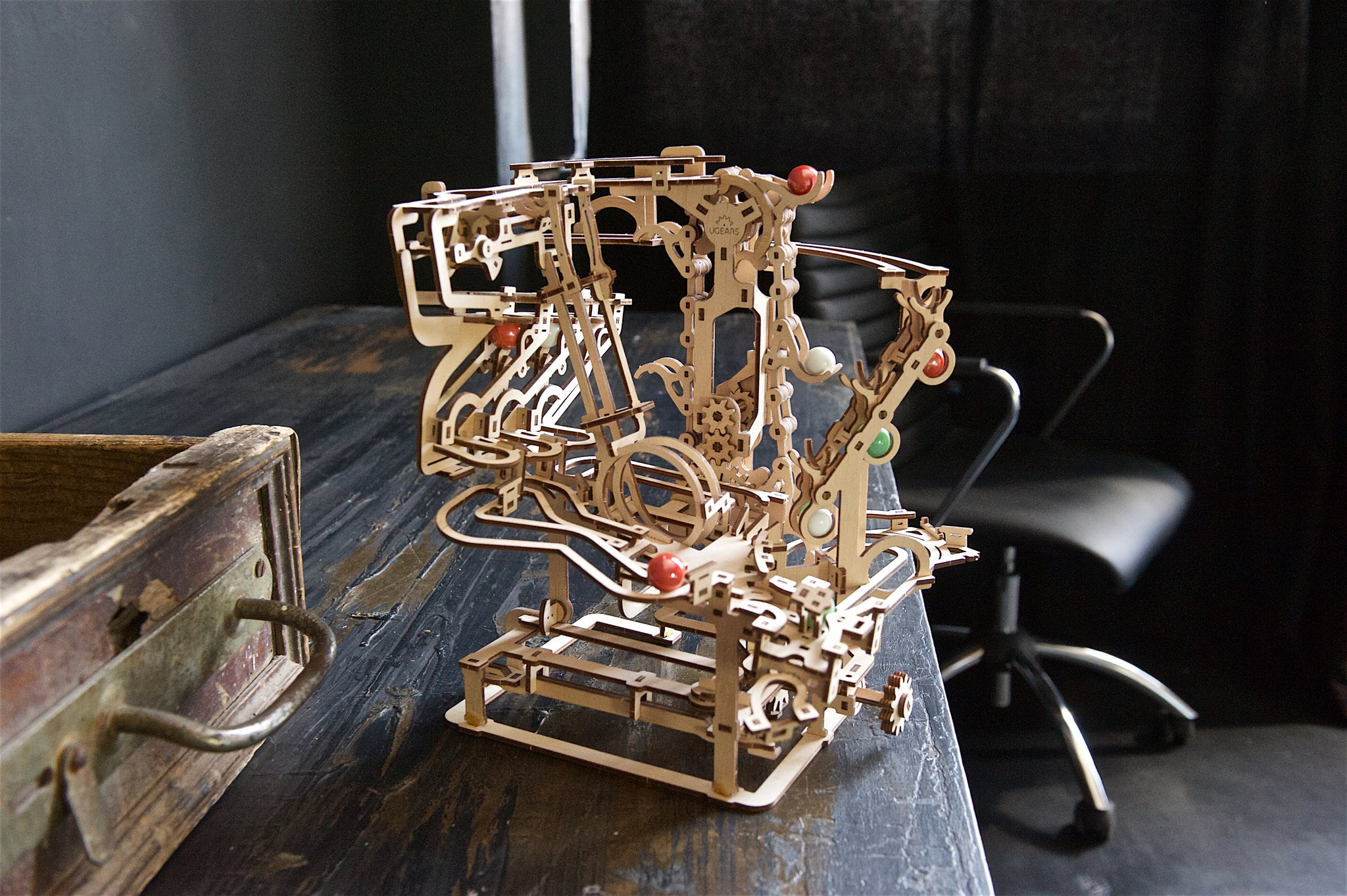 Un modèle mécanique en bois avec des billes sur une table.