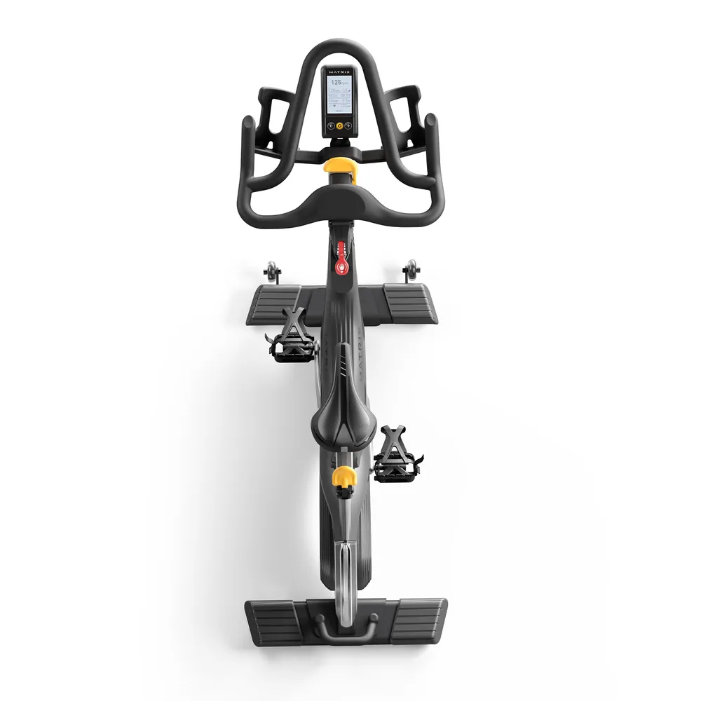 Ein schwarzes Indoor-Fahrrad mit silbernem Lenker und Display. Gelbe Akzente an Sattel und Pedalen.