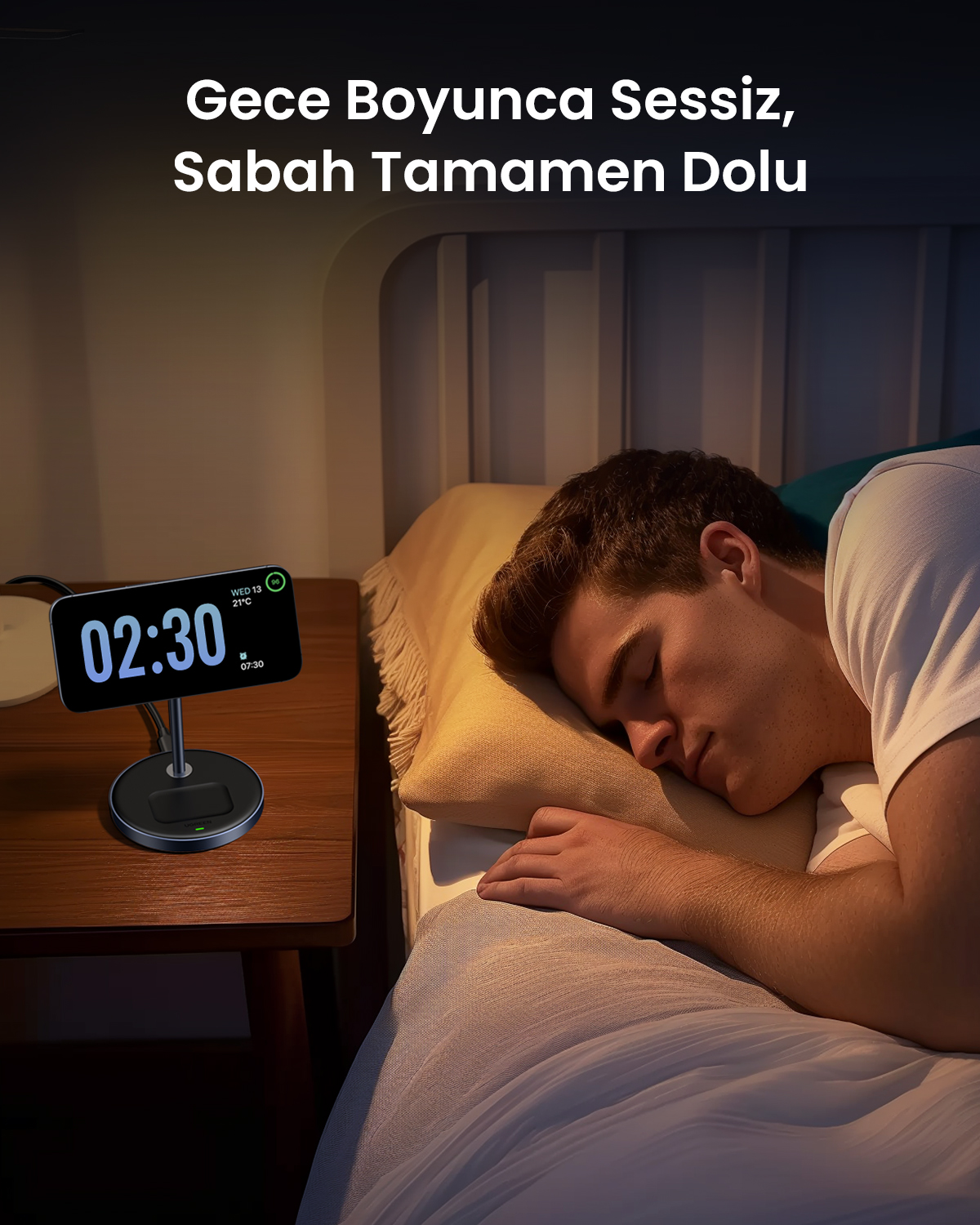 Bir adam yatakta uyuyor, yanında şarj cihazı ve 02:30 gösteren saat var.