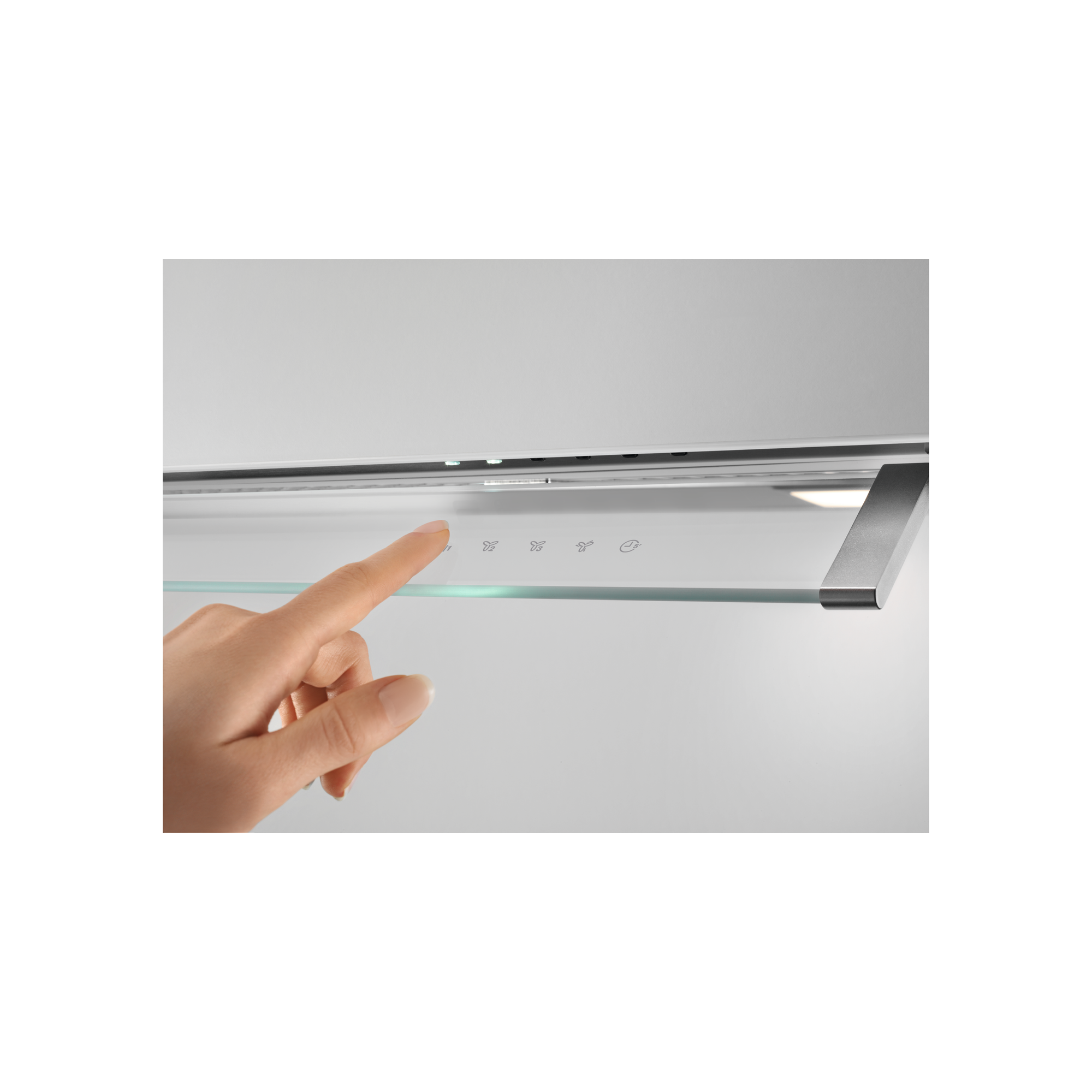 Una mano toca los controles táctiles de una campana extractora con símbolos de ventilador y luz.