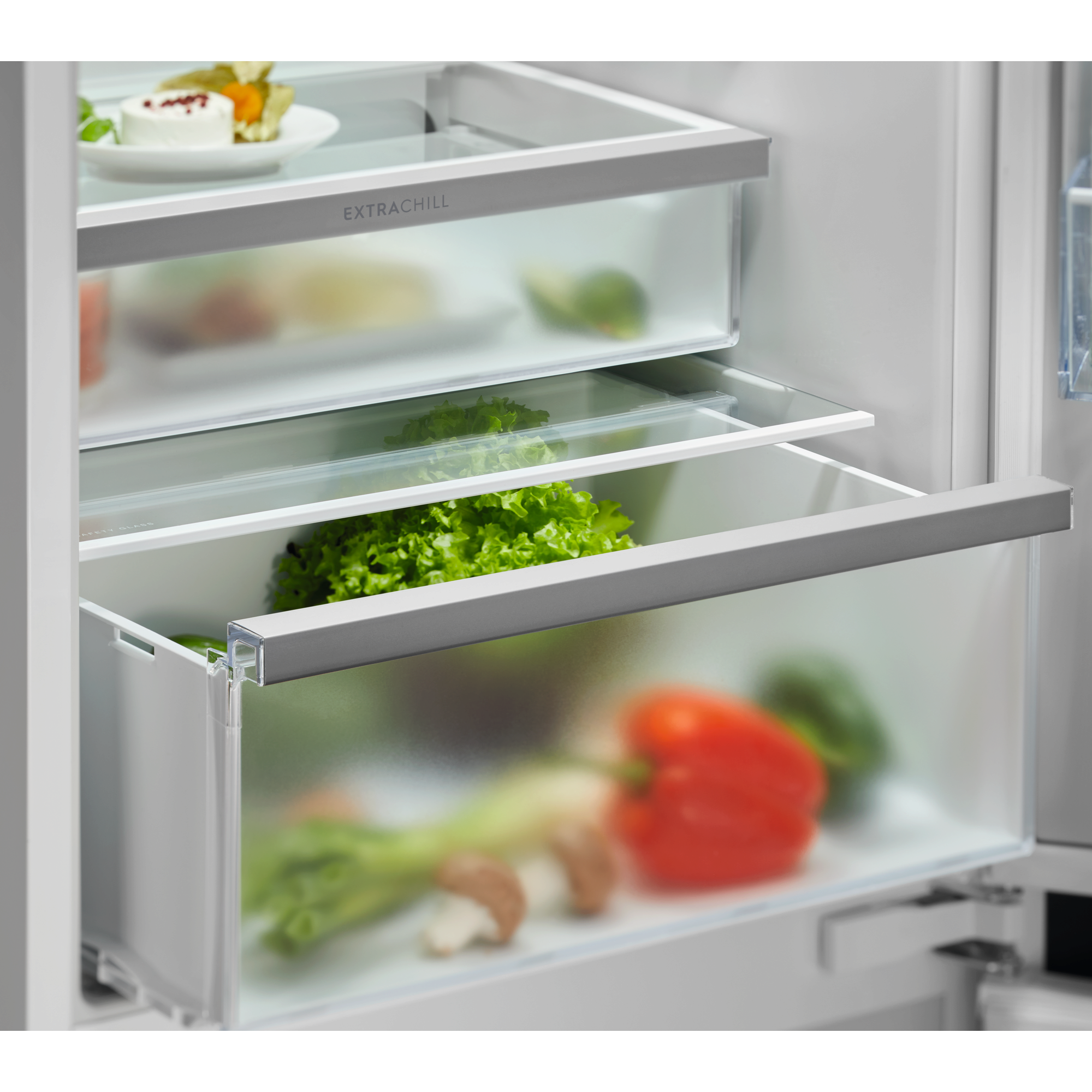 Cajones de refrigerador con comida fresca, queso y verduras. Uno dice "Extrachill".