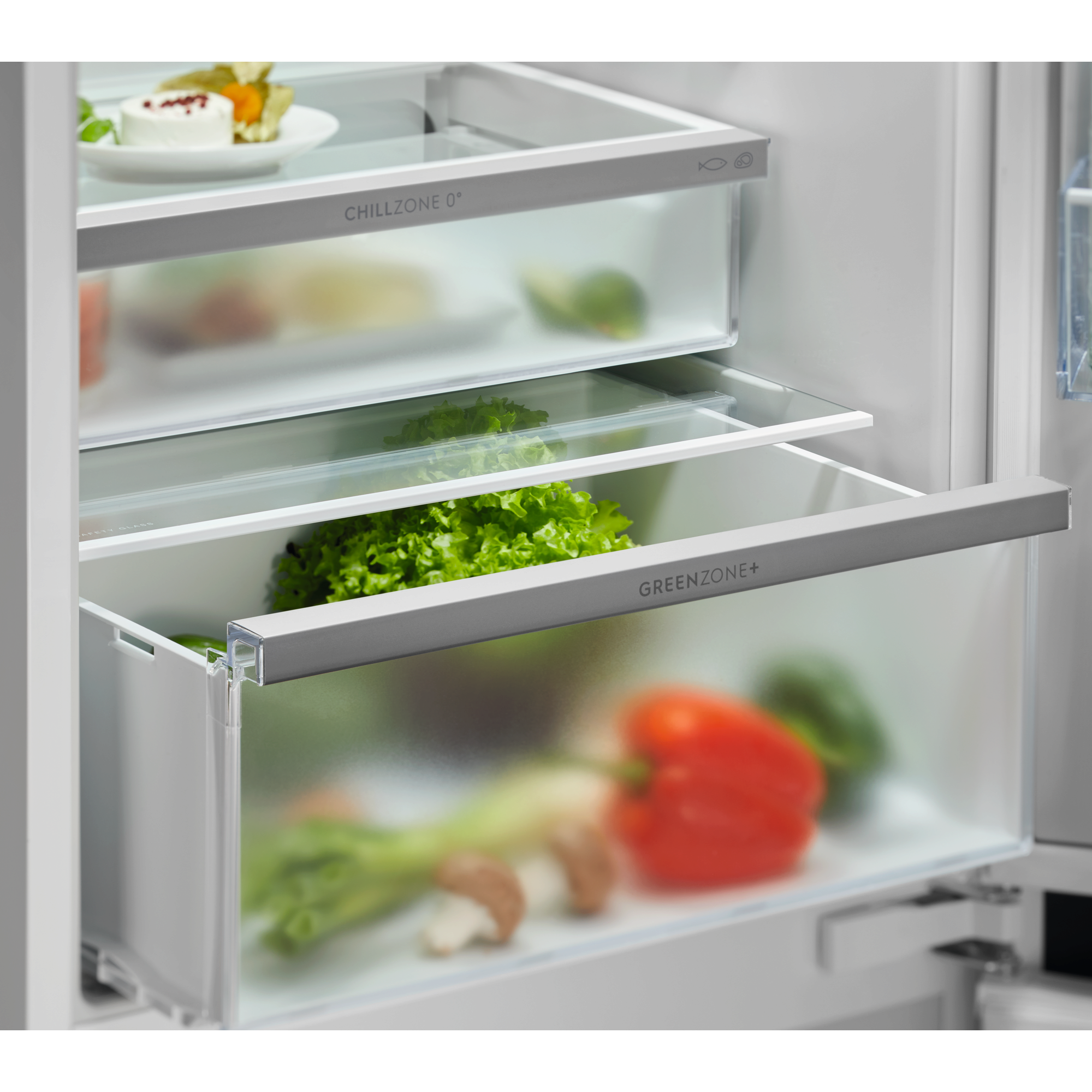 Cajones de refrigerador con verduras: lechuga, pimiento, champiñones, zanahorias.