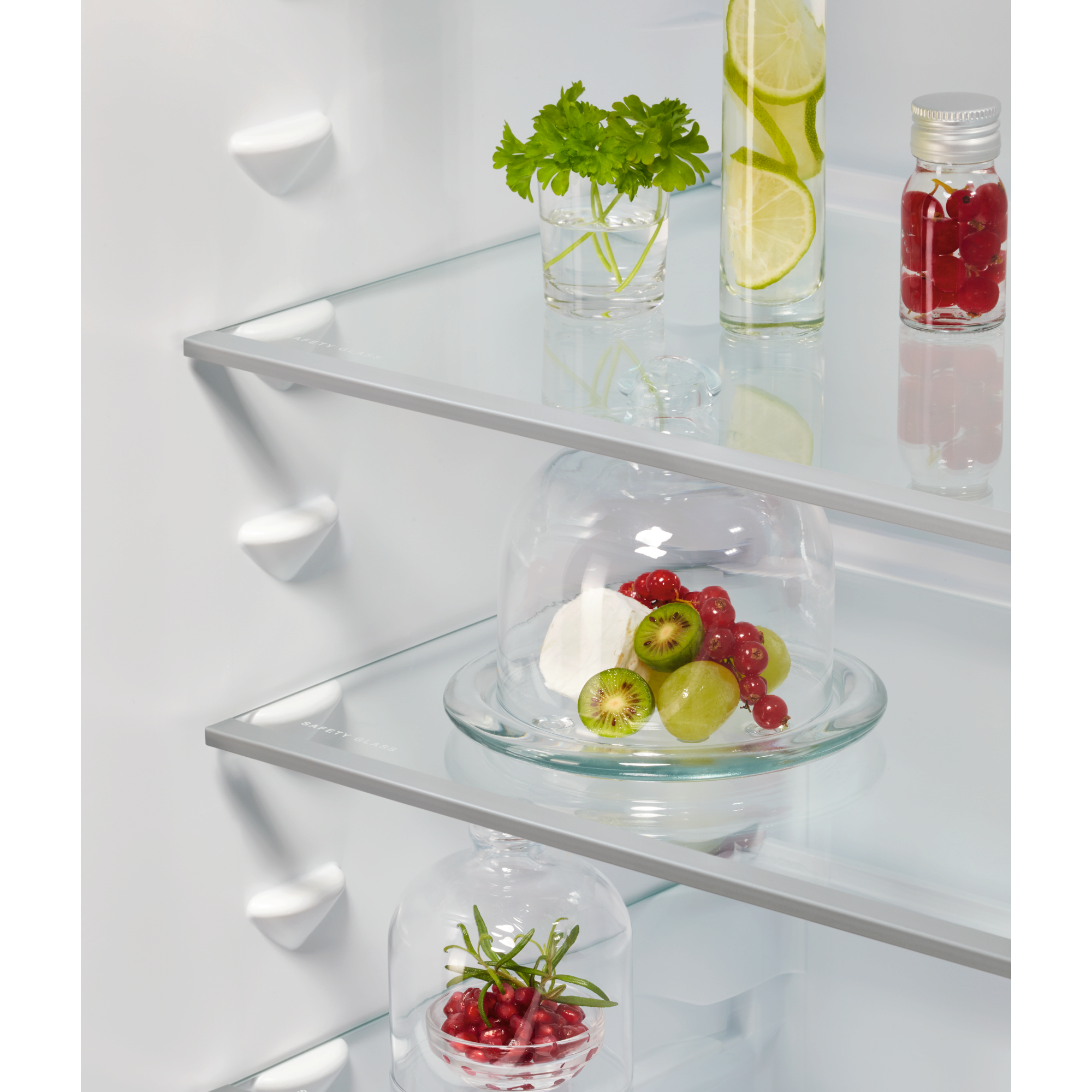 Frutas y hierbas en estantes de refrigerador.
