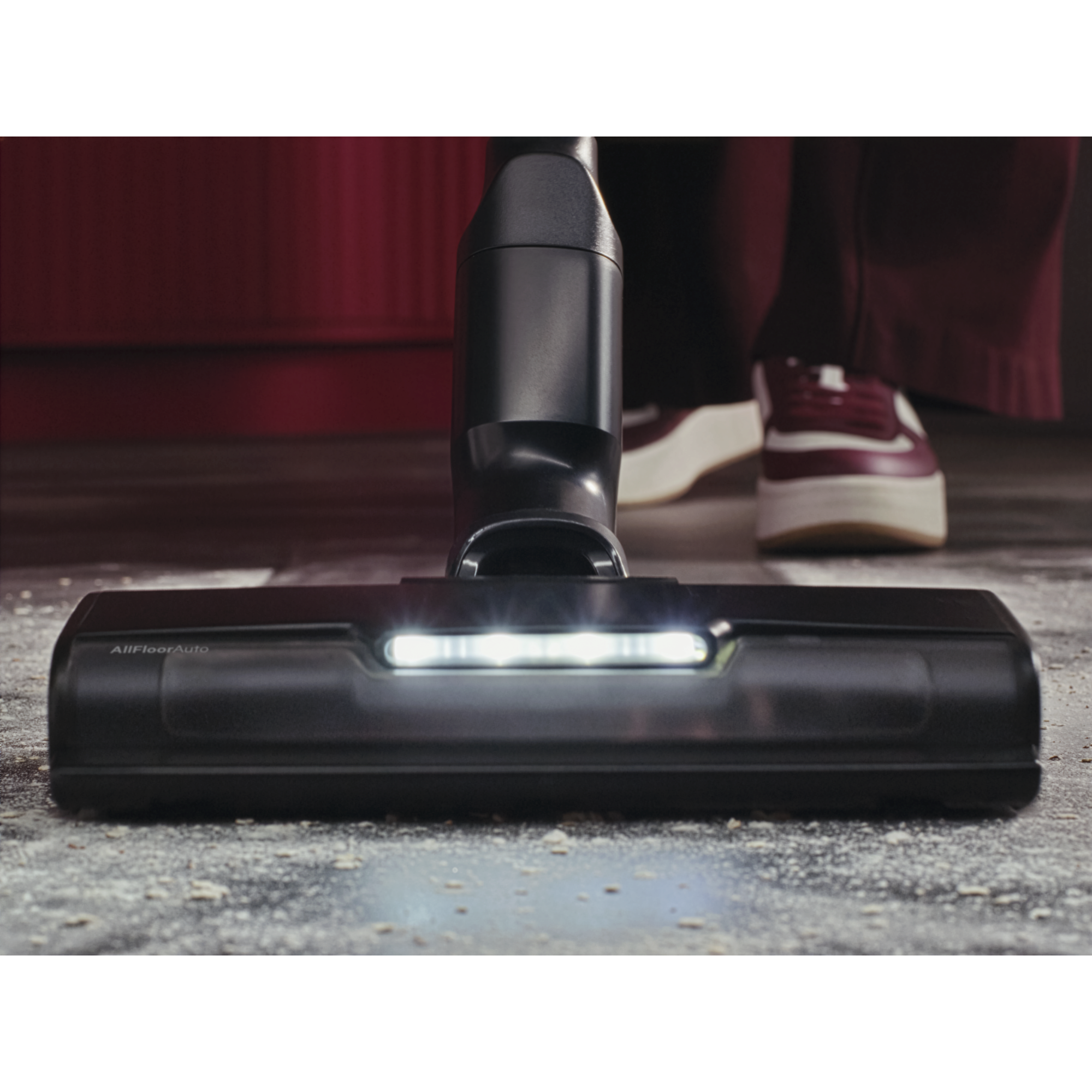 Testina aspirapolvere con luce LED su pavimento sporco.
