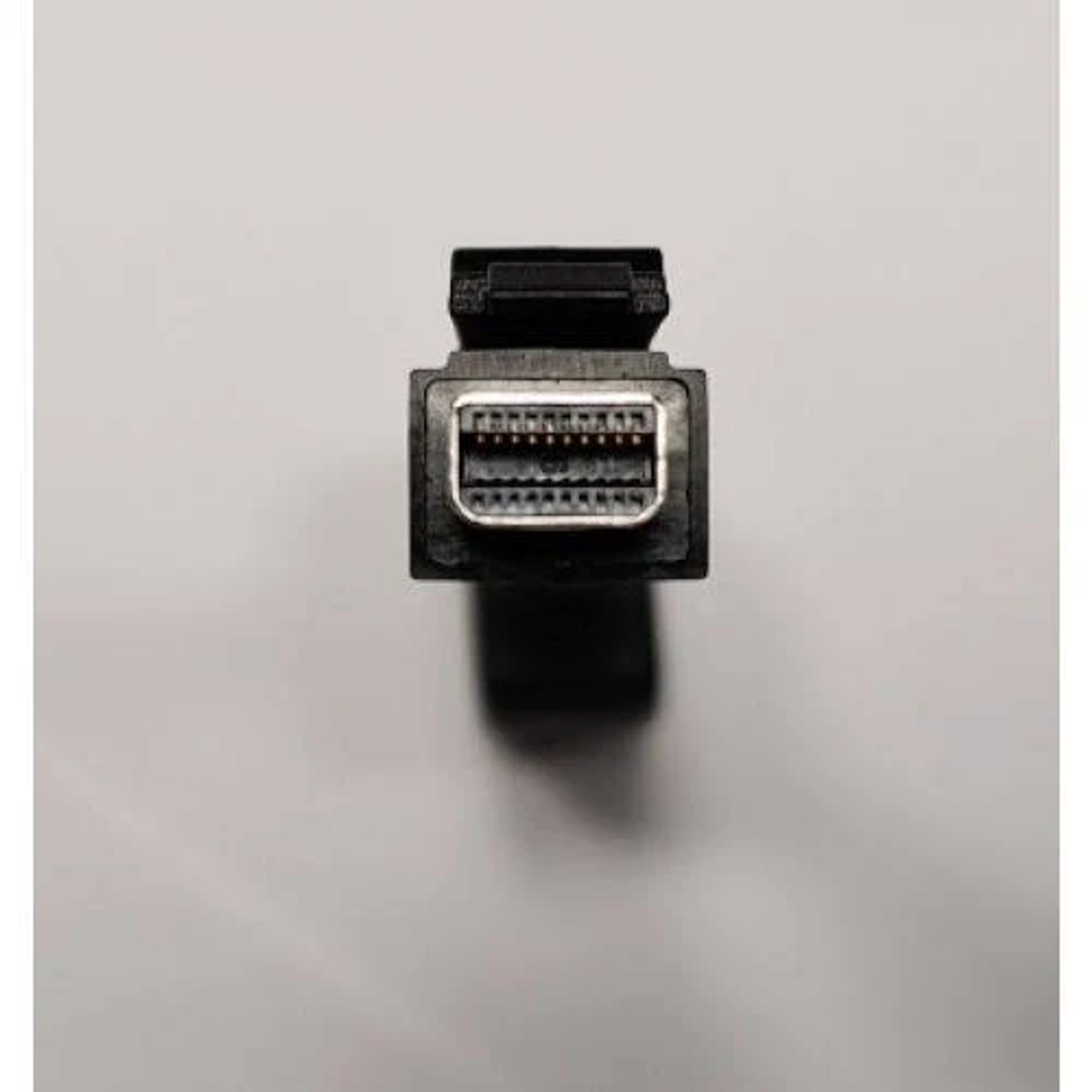 Un connettore DisplayPort nero con pin metallici su sfondo grigio.