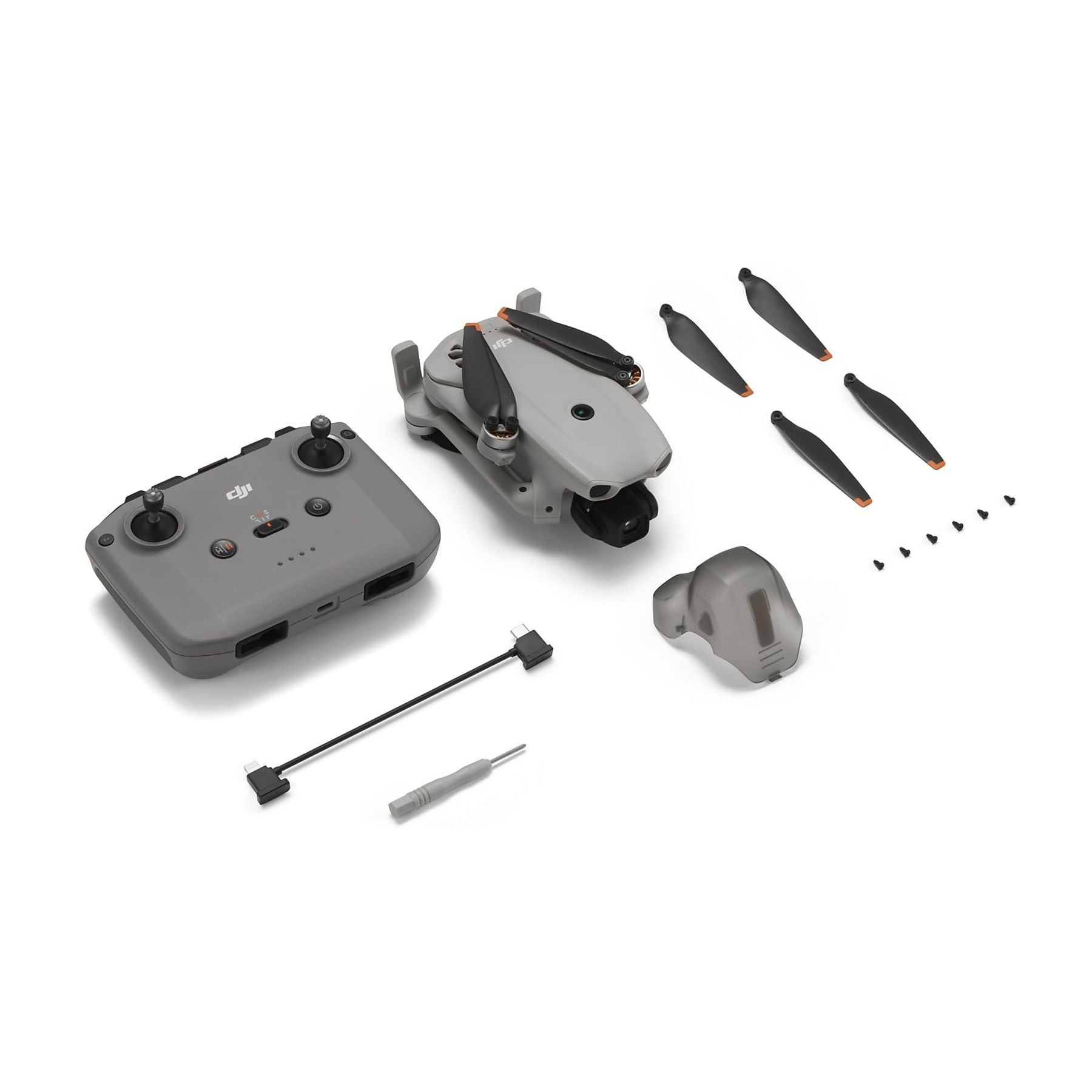 Drone gris, mando, hélices, tornillos, cable y protector de cardán en blanco.